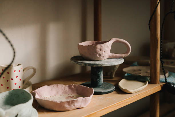 istock Shelf with handmade clay cups and plates in the pottery studio. Creating ceramics ware with own hands. 2198763120