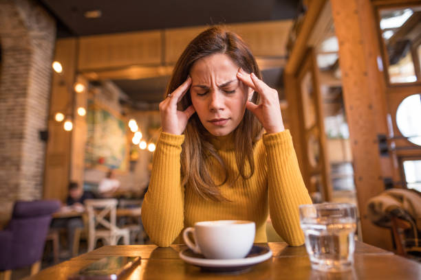 istock A woman is sitting in a cafe and has a bad headache 2198764229