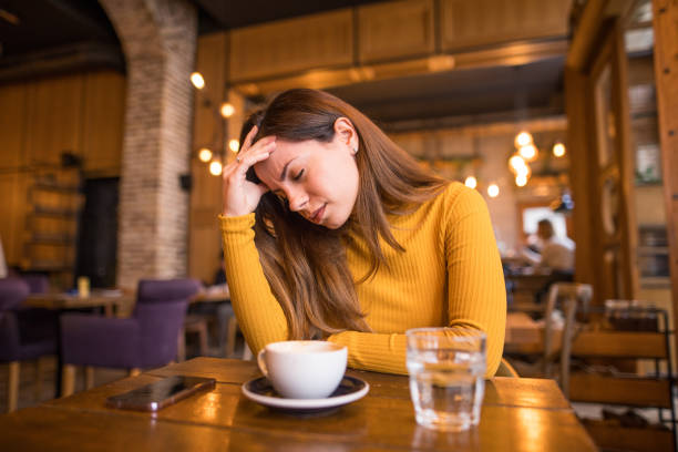 istock A woman is sitting in a cafe and has a bad headache 2198764245