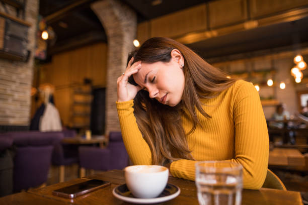 istock A woman is sitting in a cafe and has a bad headache 2198764293