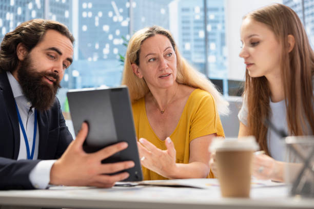 istock Consultant utilizing financial planning software on tablet to help family 2198769194