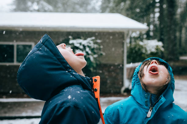Boys Catch Snowflakes on Their Tongues