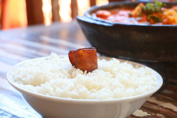 Rice topped with plantain, served in a porcelain bowl. Side dish.