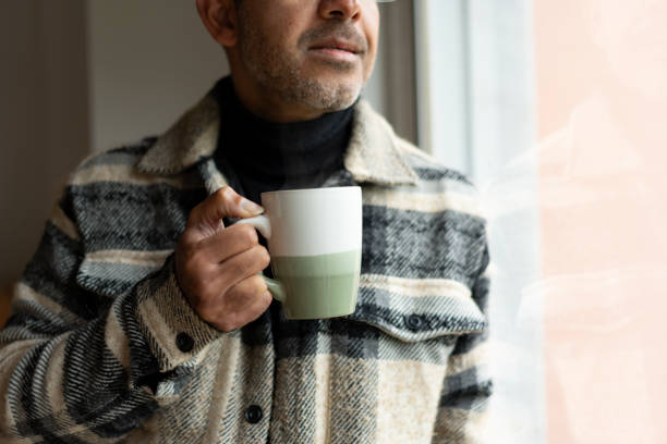 istock Portrait of man drinking tea by the window 2198774276