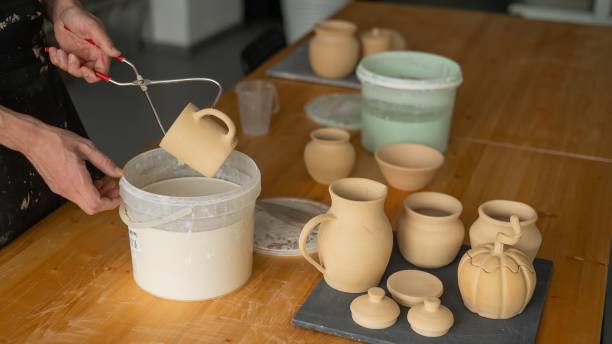 istock Close-up of a potter's hands glazing a ceramic mug. 2198775602