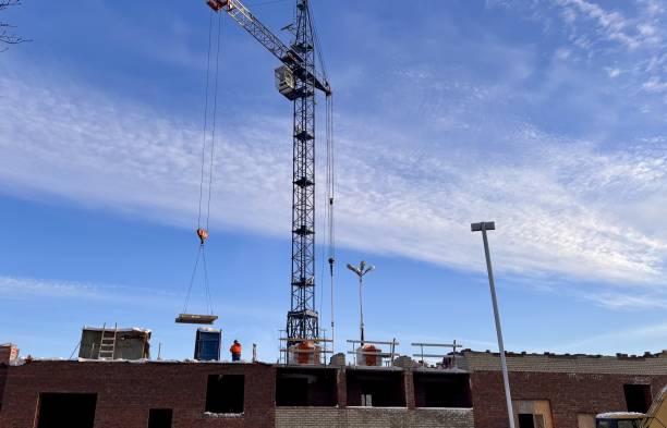 istock Construction crane and vehicles outdoors on the background buildings in winter 2198778655