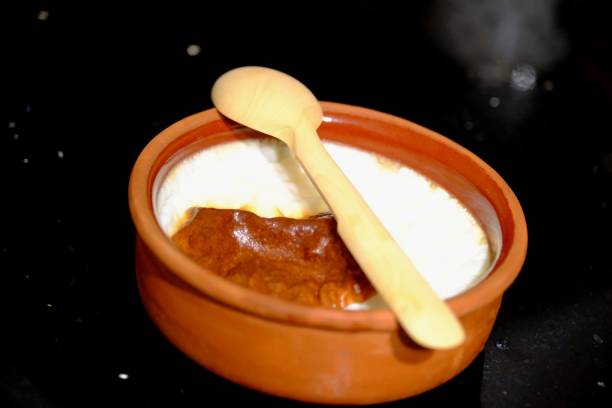 istock Oven rice pudding made in a casserole on a black background, with a wooden spoon next to it. 2198780156