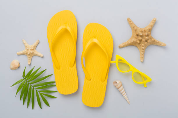 istock Bright yellow flip-flops on color background, top view. Summer concept 2198781426