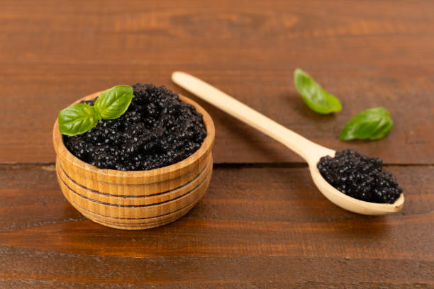 istock Bowl with black caviar on on wooden table 2198781716