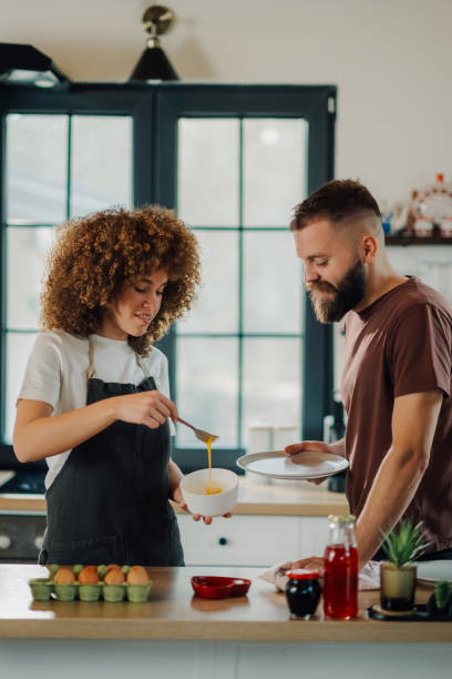 istock Couple preparing food in kitchen, woman whisking eggs 2198785706