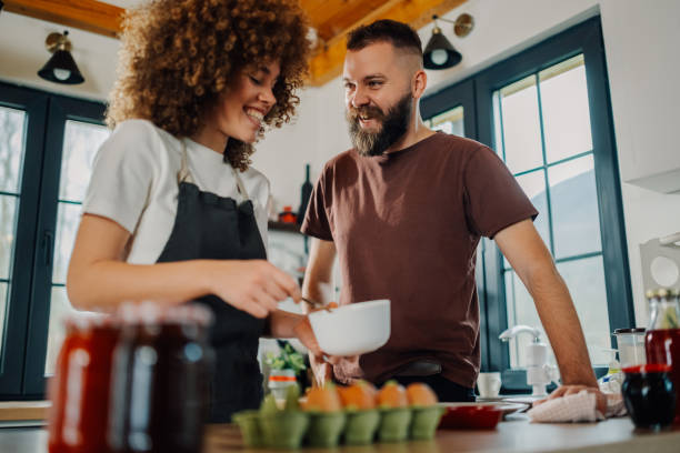 istock Happy couple preparing food together in modern kitchen 2198785785