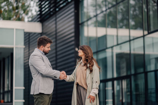 istock Business people shaking hands in front of office building 2198786164
