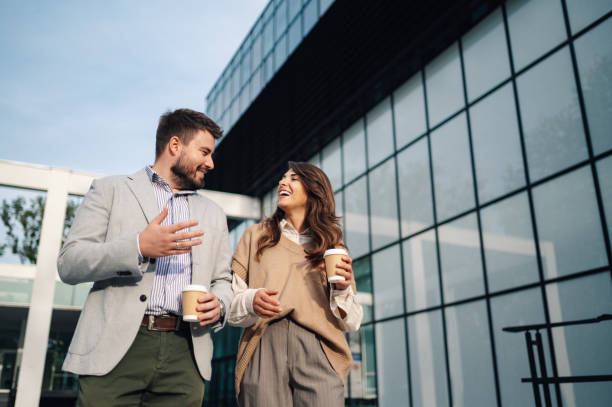 istock Business people having coffee break walking outside office building 2198786179