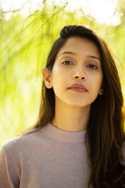 istock Close up beautiful young woman by tree 2198786651