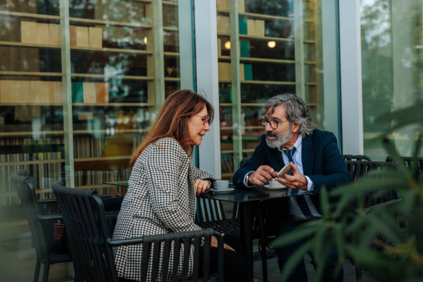 istock Business partners having a meeting at a cafe, discussing work and using a smartphone 2198786835