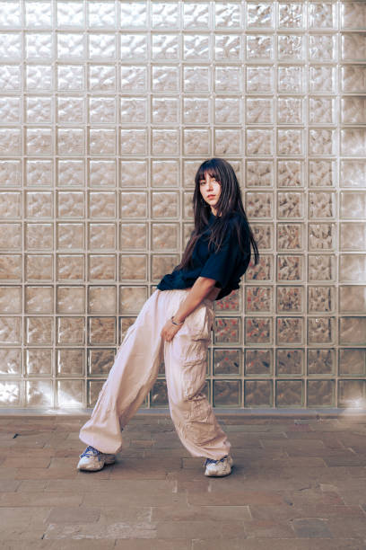 istock Young dancer poses creatively in a minimalistic urban setting with glass wall background 2198787656