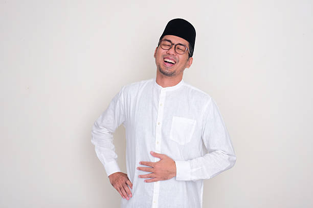 istock Muslim man touching his stomach showing relieved face expression 2198787972