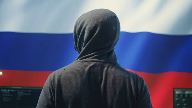 Expert in governmental hacking room with a Russian flag on big screen