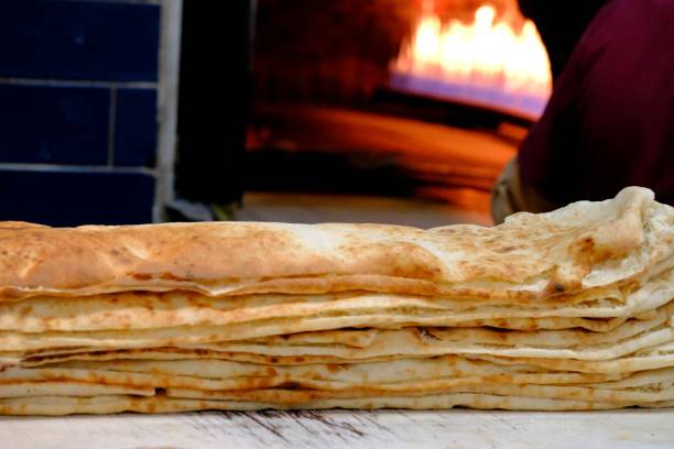 istock Making Ramadan pita on wood fire in a stone oven 2198795139