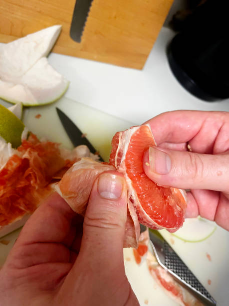 istock A freshly cut pomelo being prepared, revealing its thick white pith and juicy inner orange segments, showcasing the intricate layers of this tropical citrus fruit 2198799055