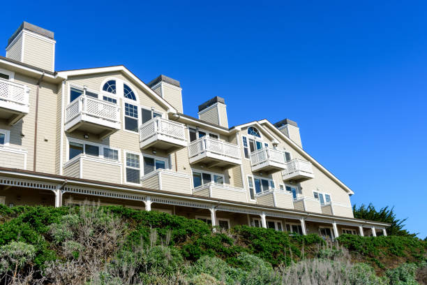 istock Modern seaside residential apartments building with beige siding, white balconies, and arched windows. 2198799444