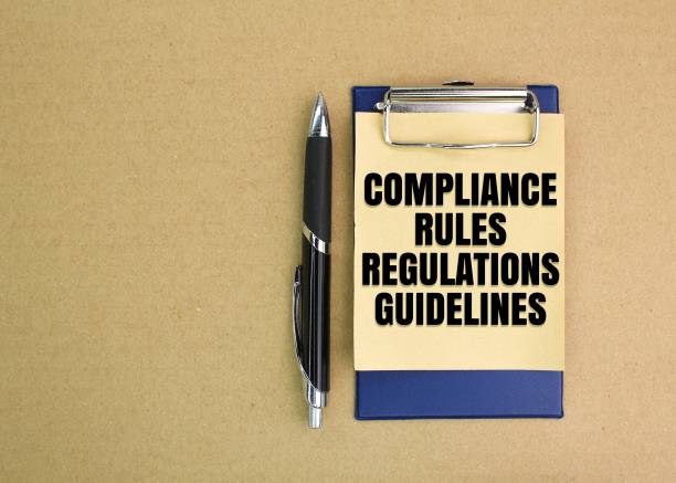 istock pen and paper board write the words COMPLIANCE RULES REGULATIONS GUIDELINES. 2198800382