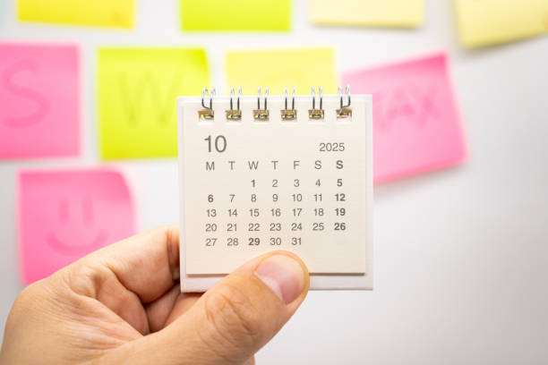 istock Hand holding mini calendar for OCTOBER 2025 background. Calendar concept with 2025 OCT calendar. Sticky note 2198802596