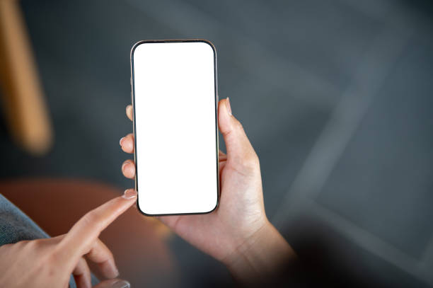 istock A close-up top view of a woman using a smartphone while sitting indoors. 2198804711