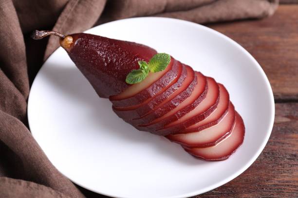 istock Tasty red wine poached pear on wooden table, closeup 2198805431