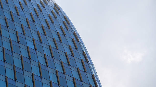 istock Curved Glass Facade - Modern skyscraper with repeating geometric patterns and a sleek curvature, perfect for showcasing architectural innovation, urban design concepts, or modern minimalism 2198806625