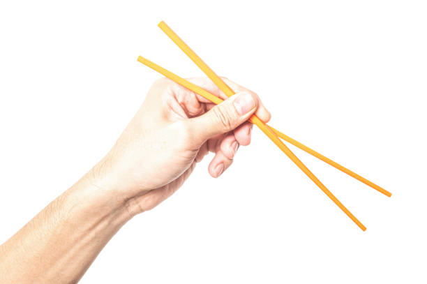 istock Male hand holding a orange plastic chopstick isolated on white background. 2198807190
