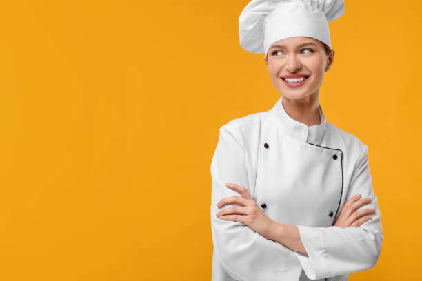 istock Happy chef in uniform on orange background, space for text 2198808084