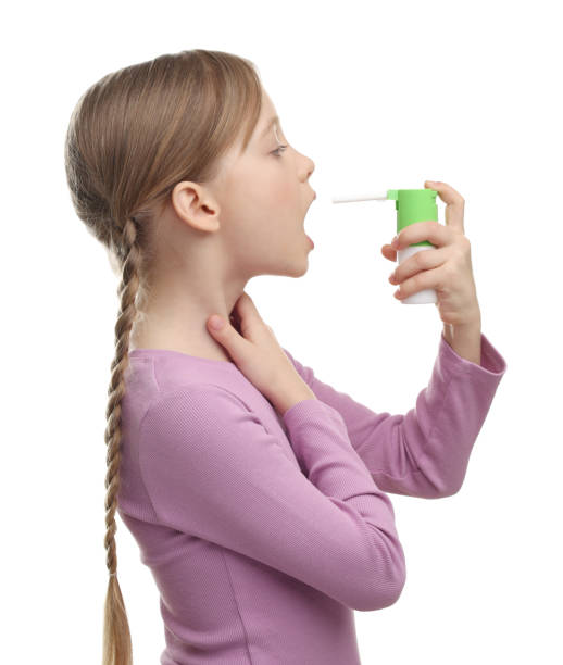 istock Little girl using throat spray on white background 2198808188
