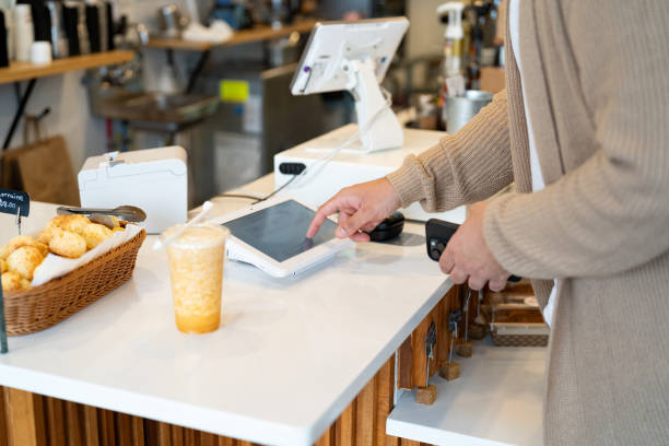 istock Young man making a payment in a local business using cellphone 2198811095