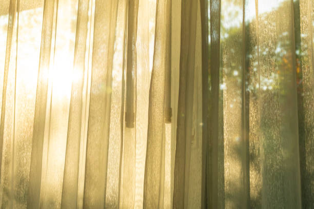 istock Soft light on curtains window. There was morning light through the window in room, looking at the view of the mountains and trees as the sun rose. 2198814903