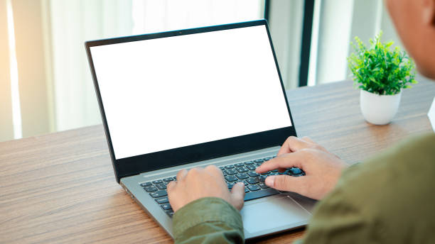 istock Business using and searching the information on laptop with empty screen on wooden table, template for online marketing, Mockup blank white screen laptop computer. 2198821377