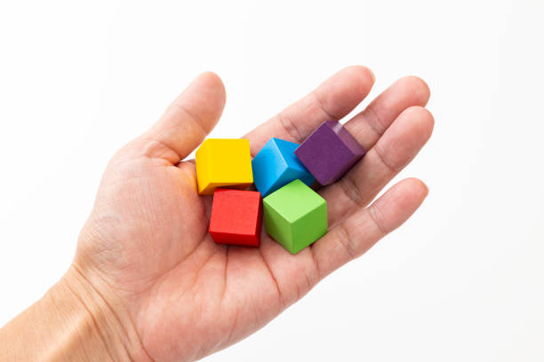 Hands holding colorful building blocks.
