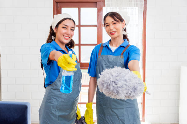 istock Two professional cleaning service workers in uniforms and gloves smile while holding cleaning supplies. Housekeeping concept, janitorial services, home cleaning, professional maid service for business 2198828249