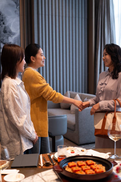 Women Meeting & Shaking Hands at a Dining Table