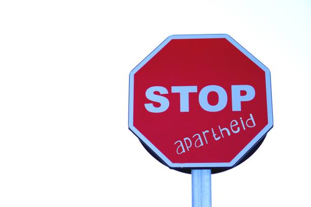 istock stop apartheid. red stop traffic sign with message in white letters. 2198830524