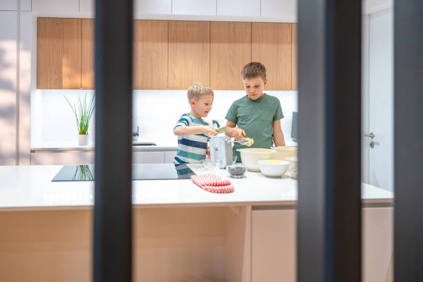 istock Young Caucasian Boys Baking Cookies Together in Kitchen 2198834751