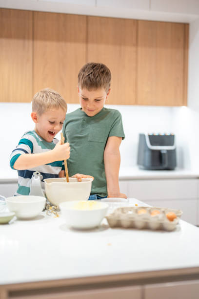 istock Caucasian Brothers Joyfully Making Cookie Dough Together 2198834776