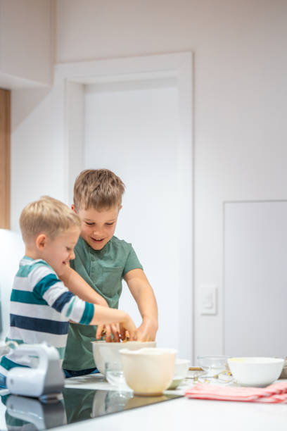istock Joyful Caucasian Brothers Baking Cookies Together 2198834784