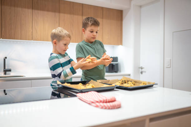 istock Caucasian Brothers Joyfully Shaping Dough in Kitchen 2198834863