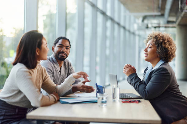 istock Happy diverse couple talking to their agent in the office. 2198835923
