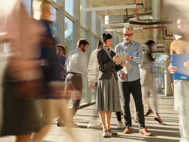 istock Diverse entrepreneurs using touchpad among colleagues in blurred motion at office. 2198836442