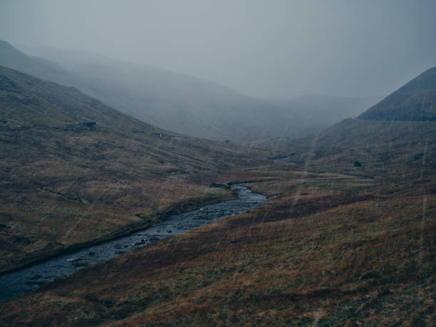 View of the stream flowing among hills during pouring rain at Faroe Islands. Photographed in medium format.
