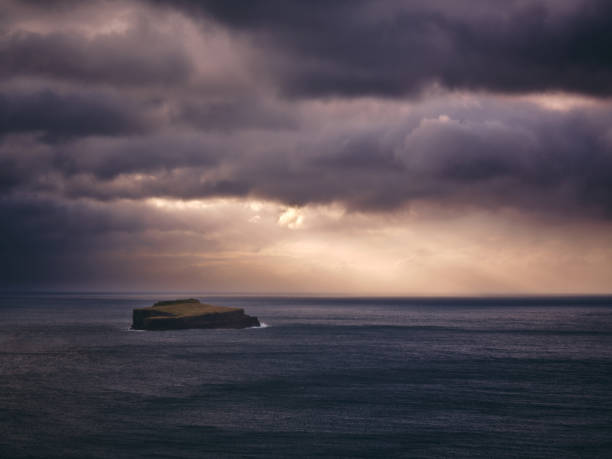 View of the stack rock in the middle of the Atlantic ocean on Faroe Islands at sunset. Photographed in medium format.