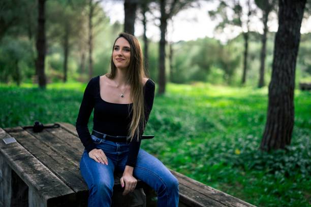 istock Woman sitting in a serene park setting 2198840871