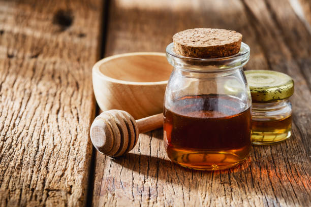 istock honey with dipper on wooden background 2198840934